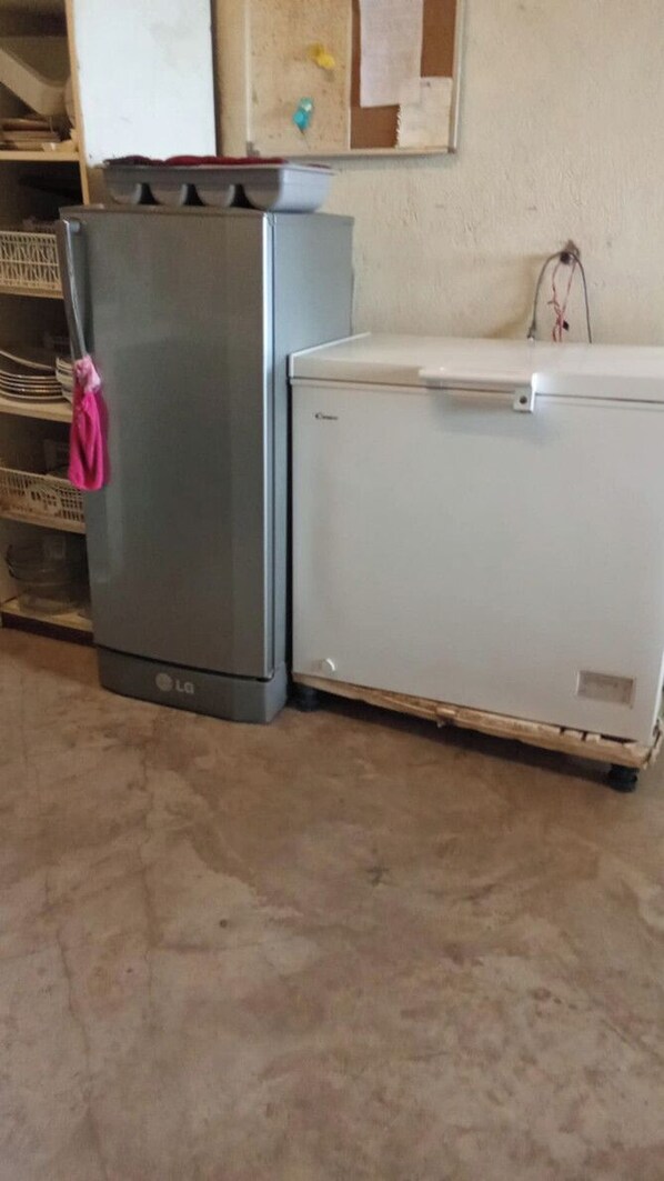A kitchen with a refrigerator and a white washing machine.