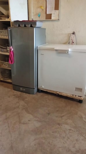 A kitchen with a refrigerator and a white washing machine.