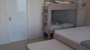 Ein Zimmer mit zwei Etagenbetten, einer Tür und einer Klimaanlage.