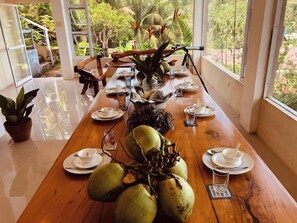 Una mesa de comedor dispuesta con platos, tazas y un gran centro de cocos.