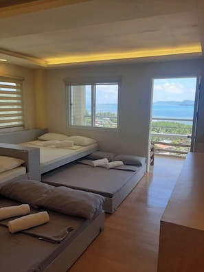 Un dormitorio moderno con cama, sofá y vista al mar.