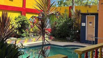 A pool area with a bench, surrounded by colorful decorations and plants.