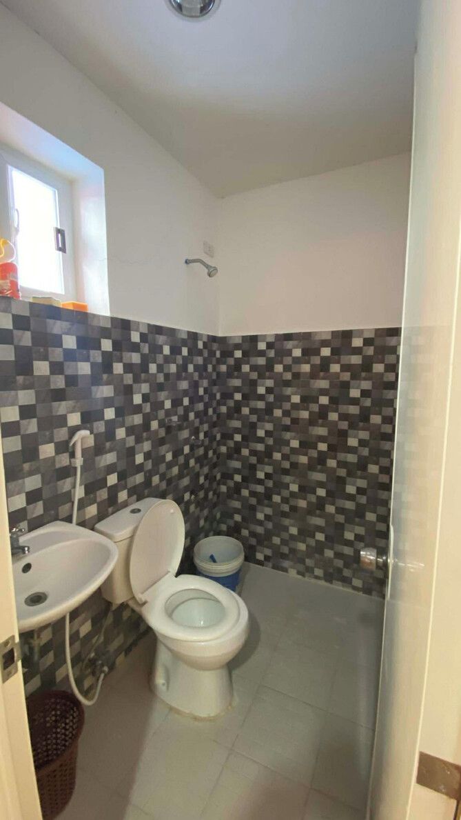 Un bagno con parete piastrellata, lavabo, WC e doccia.