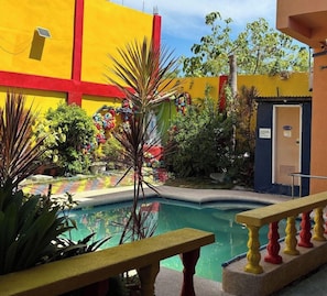 A pool area with a bench, surrounded by colorful decorations and plants.