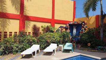 A pool area with lounge chairs and a decorative fountain.