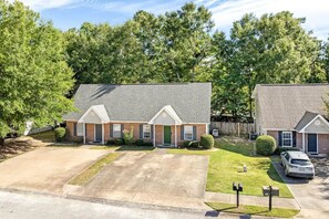 A residential area with two brick houses, each with a garage, driveway, and front yard. - King Bed 3B Townhome 2.7 miles from the stadium. (Auburn)