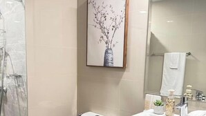 A bathroom with a toilet, bidet, shower, and sink. - Kuya Awen’s Staycation 12H (Parañaque)