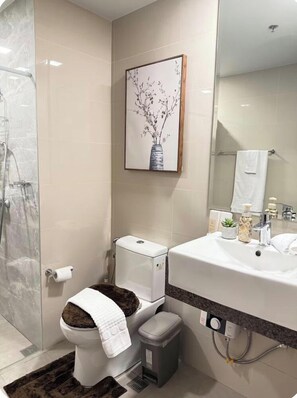 A bathroom with a toilet, bidet, shower, and sink. - Kuya Awen’s Staycation 12H (Parañaque)