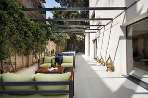 An outdoor seating area with tables and chairs, a pergola structure, and a row of decorative vases. - Cozy Stay at bait assel by spacey (cairo)