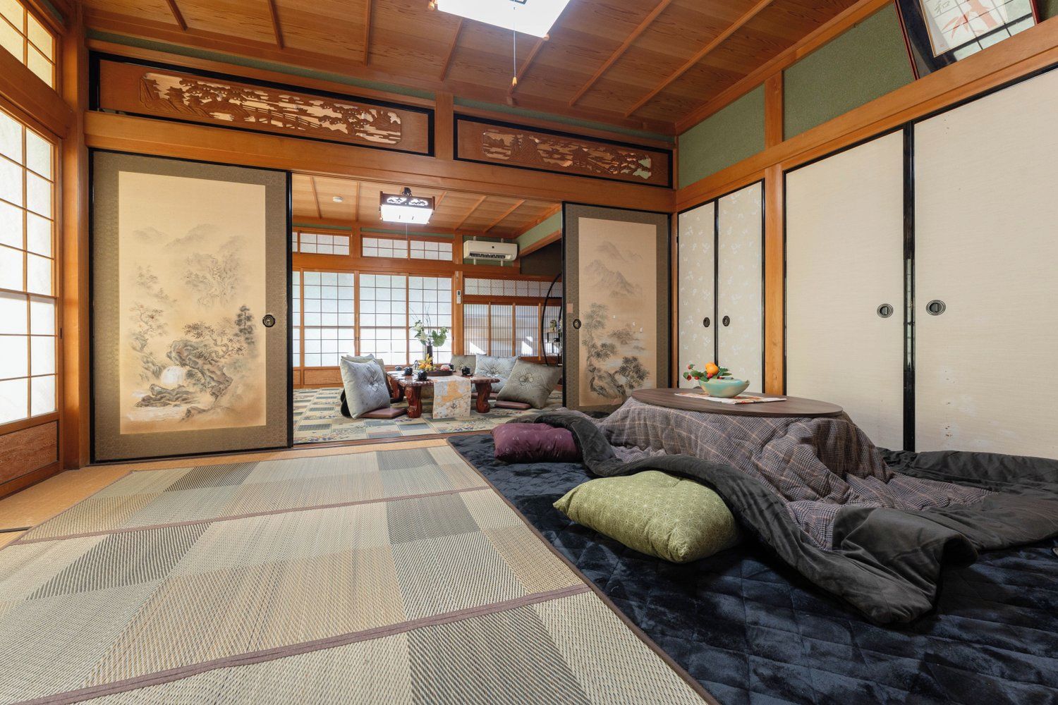 Une pièce de style japonais traditionnel, avec un sol recouvert de tatamis, des portes coulissantes et une vue sur un jardin.