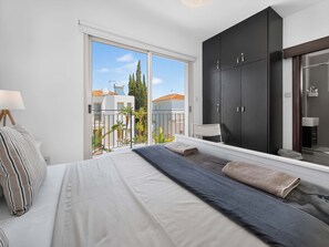 A bedroom with a bed, a large window, and a wardrobe. - Villa Andreas: Private Pool & Modern Comfort (Protaras)