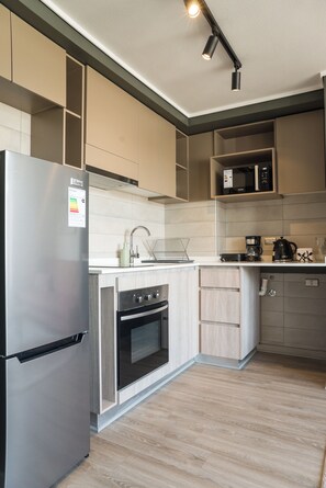A modern kitchen with a stainless steel refrigerator, an oven, a microwave, and a coffee maker. - Chic 2BR Apt in Ñuñoa with Balcony for 5 (Ñuñoa)
