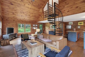 A cozy cabin interior with a living room, a dining area, and a kitchen.