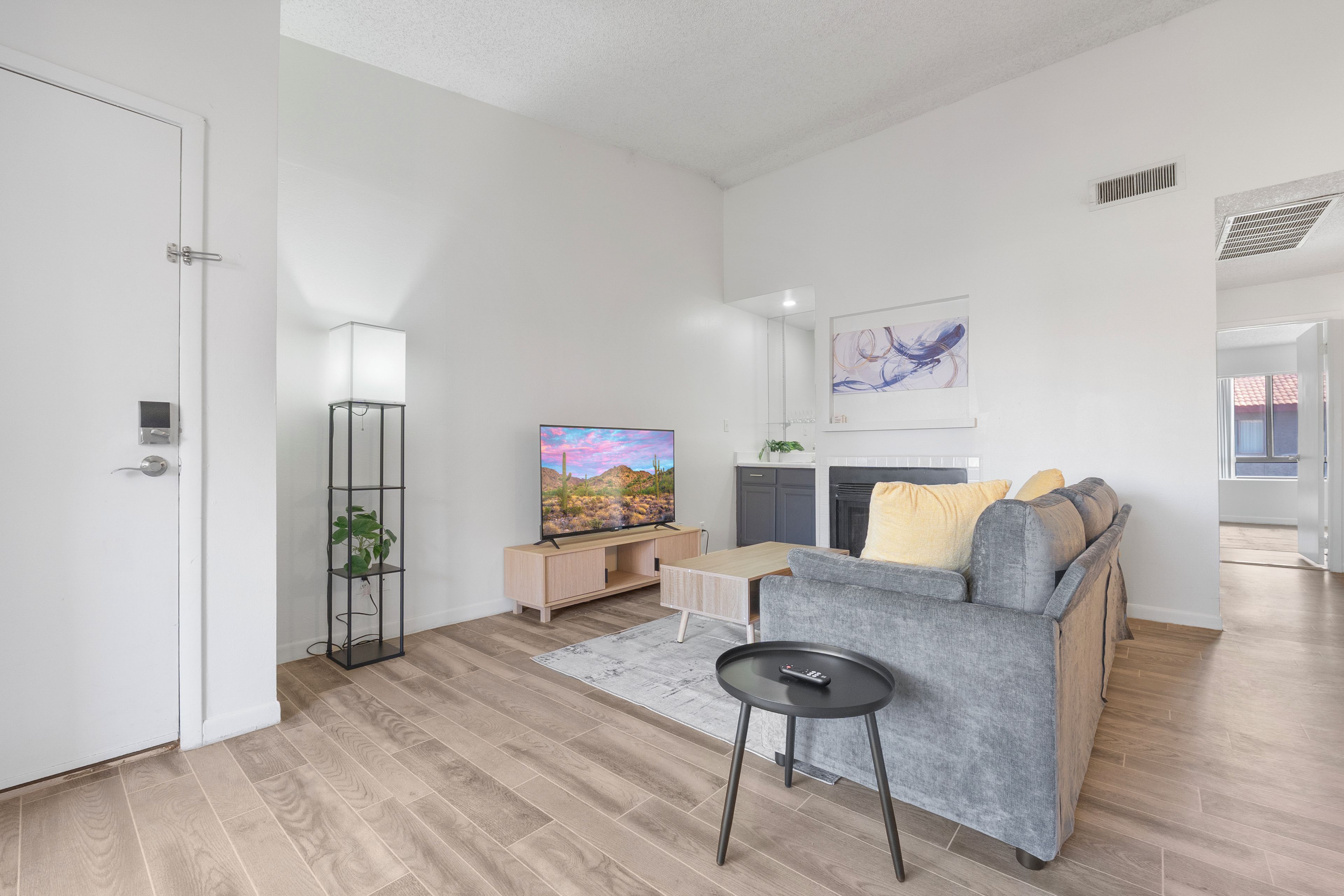 Un salon moderne avec un canapé, un téléviseur et une petite table.