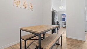 Uma cozinha moderna com forno embutido, geladeira e área de refeições com mesa e banco de madeira.