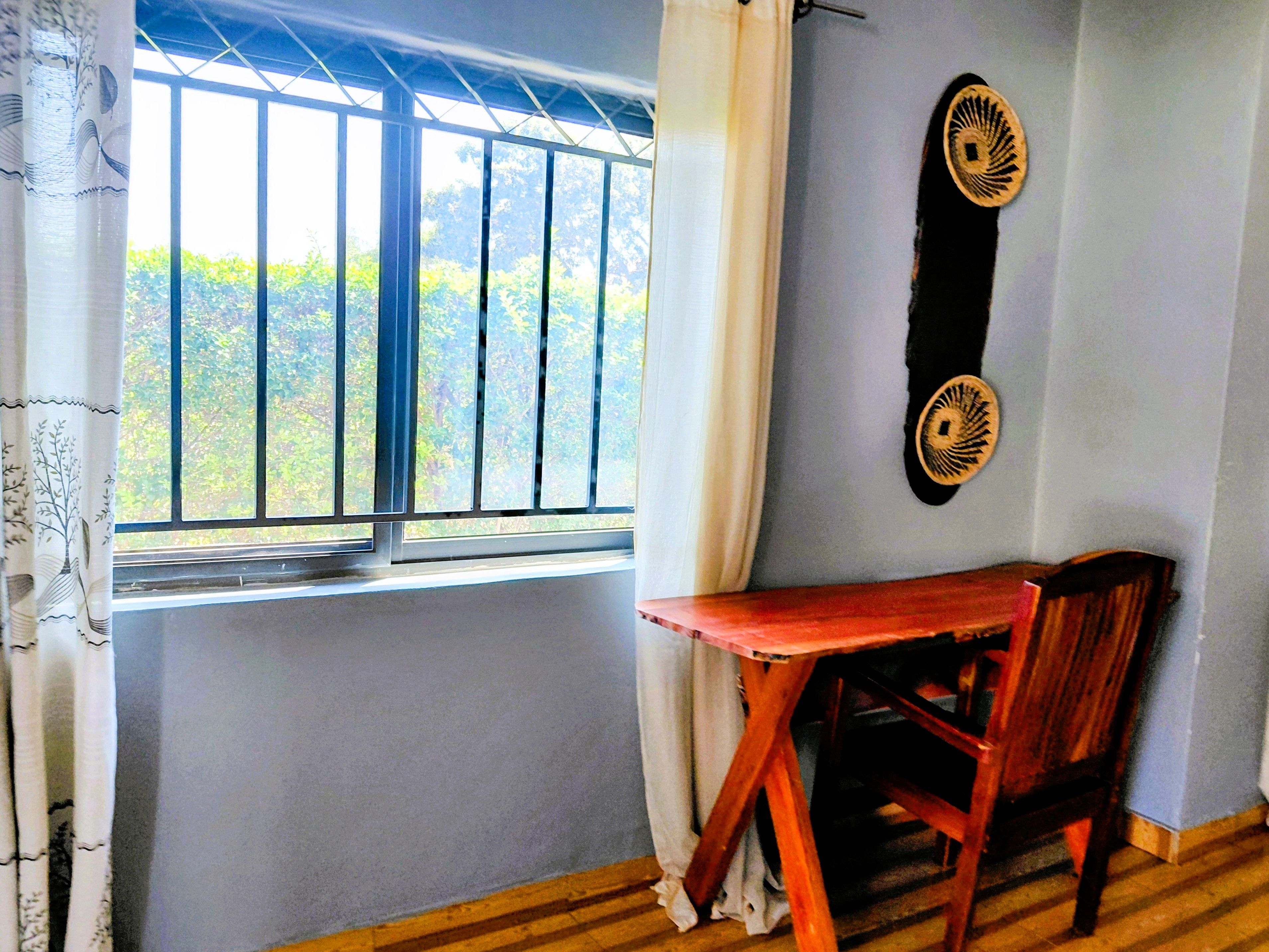 A room with a window, a table, and two chairs.