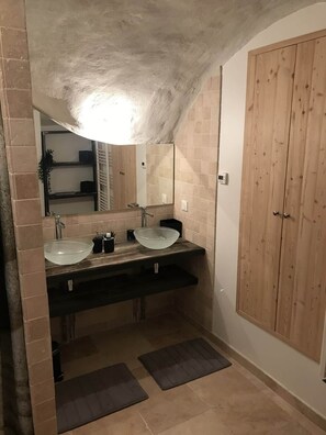 Un bagno con due lavandini, uno specchio grande e mobili impiallacciati.