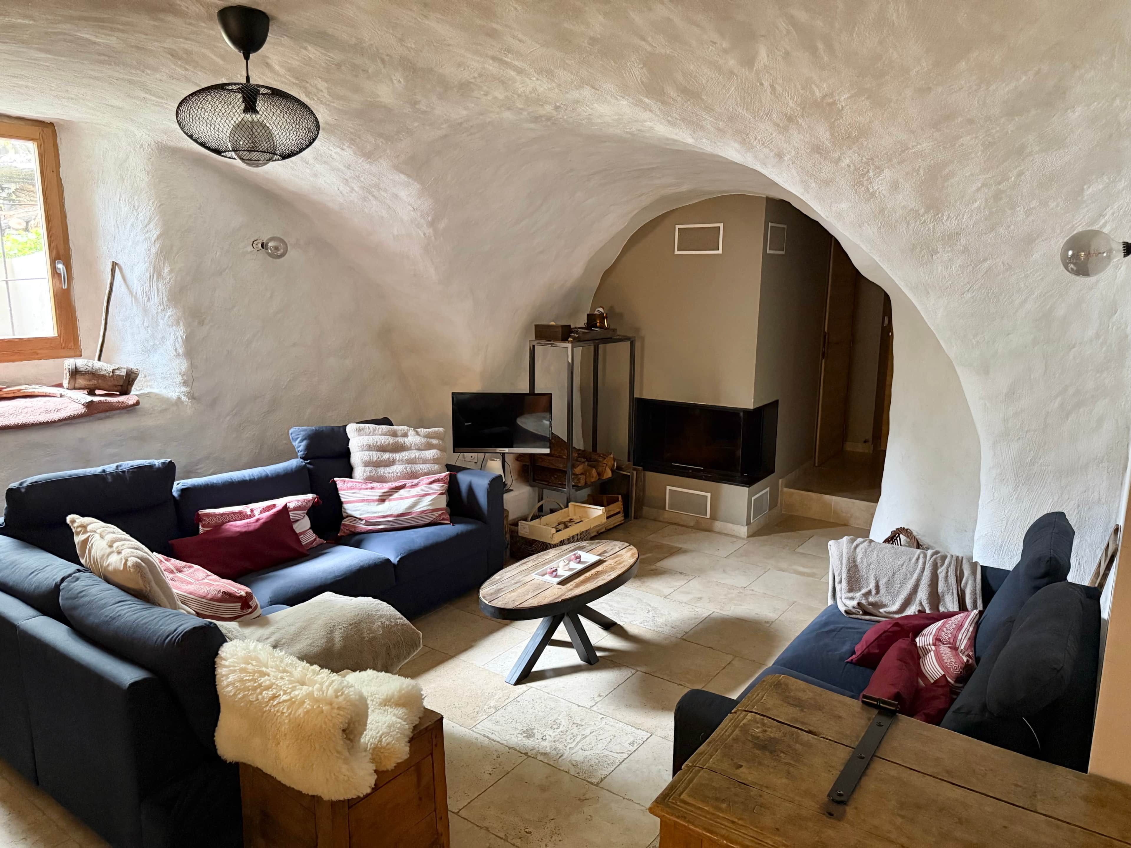 Una sala de estar acogedora con chimenea, sofás y televisión.