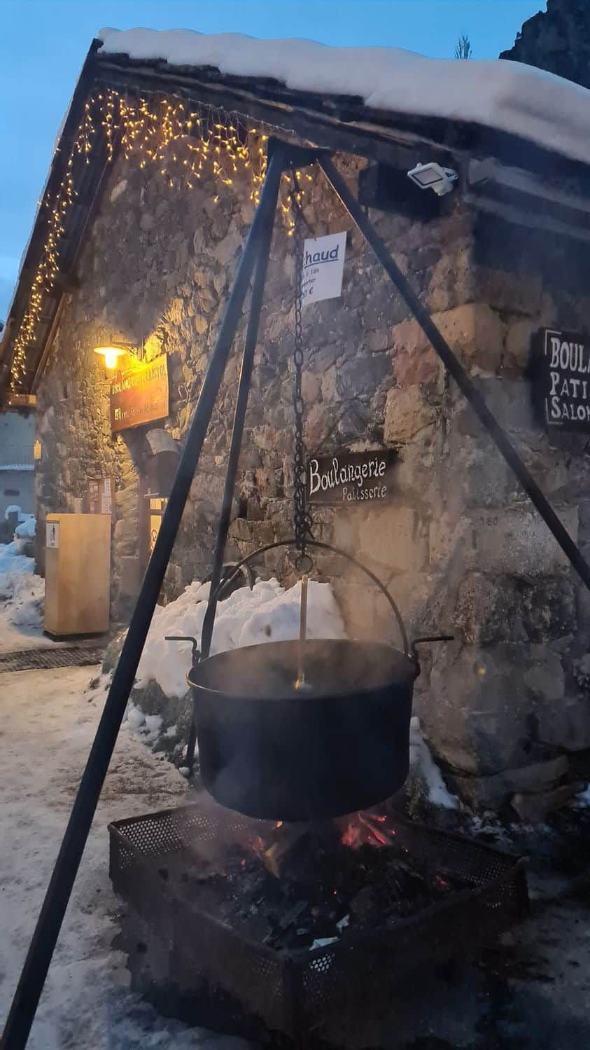 En byggnad av sten med en skylt som visar texten ”Boulangerie Patisserie” och en kastrull på en spis.