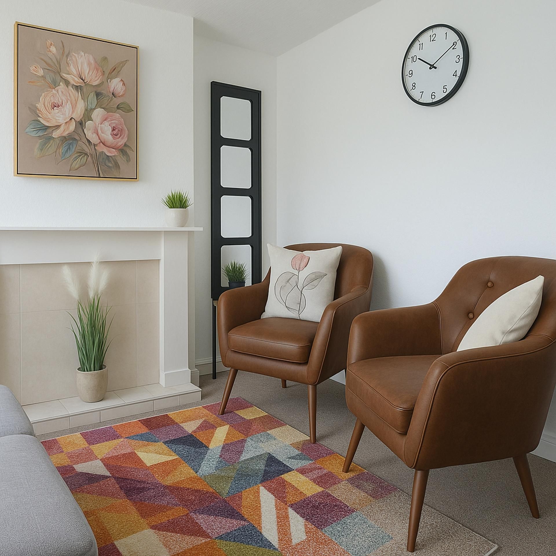Sala de estar com lareira, dois poltronas de couro marrom, tapete colorido, relógio e quadro com flores emolduradas.