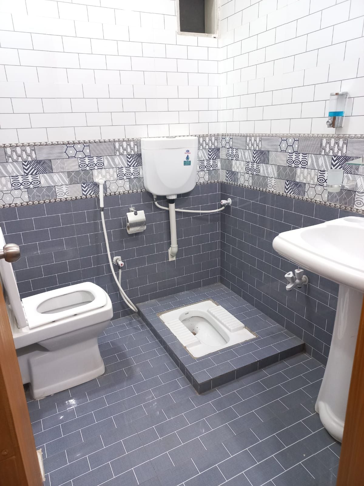 Een badkamer met toilet, bidet en wastafel.