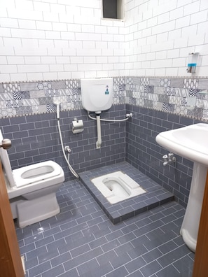 A bathroom with a toilet, bidet, and sink. - Rose Family Suites Hotel Gulshan (Karachi)
