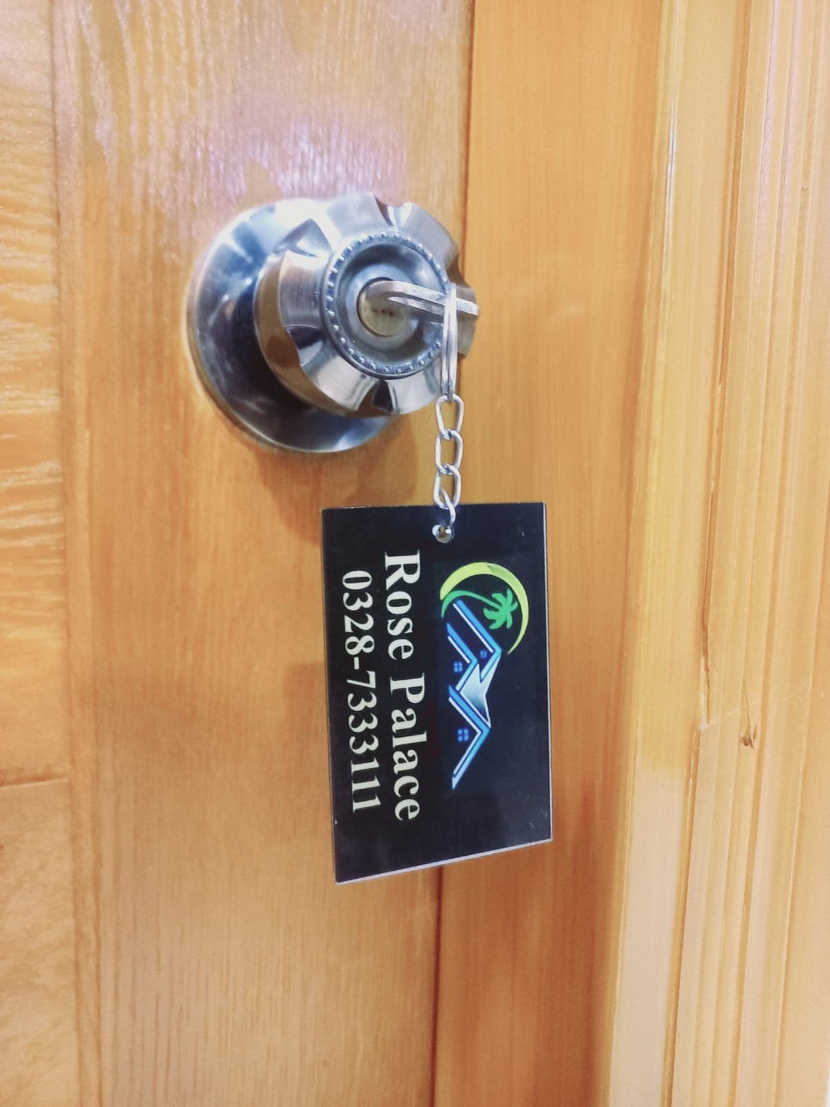 A door with a keyhole and a keychain with a black tag.