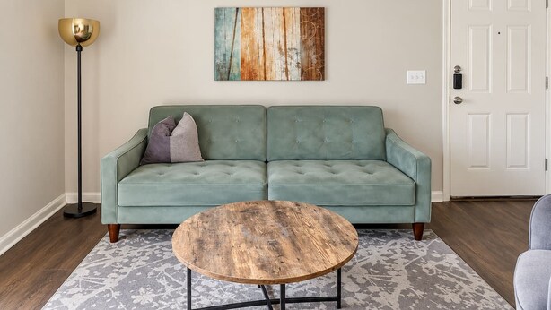 A living room with a sofa, a coffee table, a floor lamp, and a door. - Sleepover | Relaxing 1BD/1BA+ Gym - Corpus Christi (Corpus Christi)