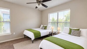 A bedroom with two beds, a ceiling fan, and a window with blinds. - Sleepover | Relaxing 1BD/1BA+ Gym - Corpus Christi (Corpus Christi)