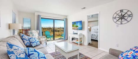 Una sala de estar moderna con un sofá, una mesa de centro y vistas al exterior.