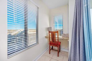 Ein Zimmer mit Fenster, Stuhl und Vorhang.