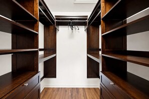 A walk-in closet with multiple wooden shelves and a white ceiling. - Lakefront w/ Resort Amenities, Multi Decks & Dogs (Hedgesville)