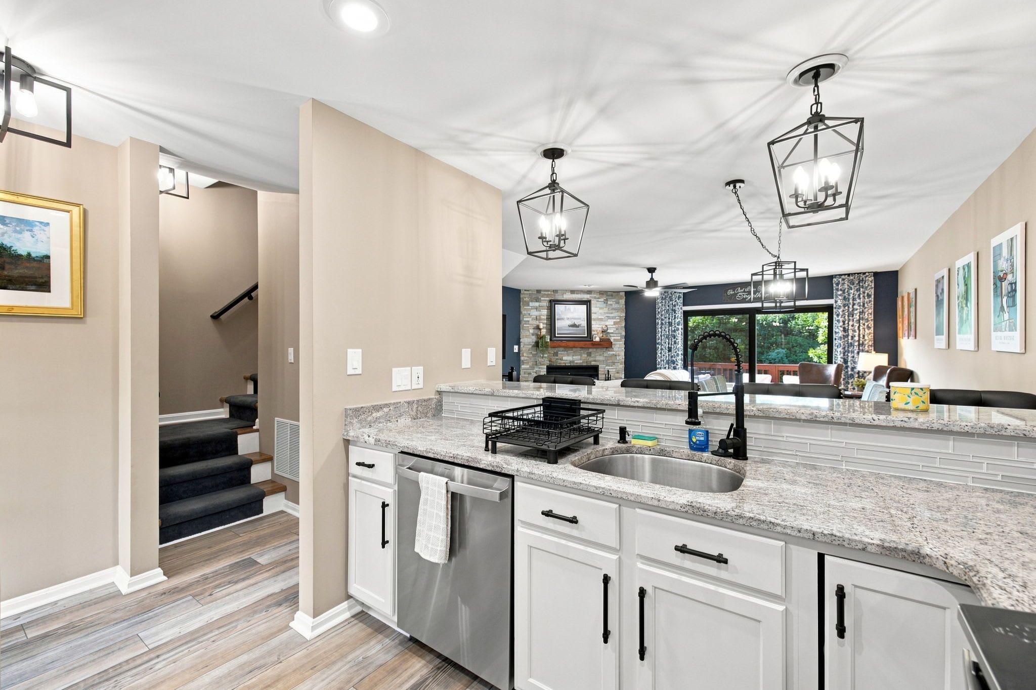 A modern kitchen with a central island, stainless steel appliances, and pendant lighting.