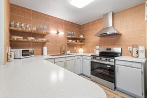 A modern kitchen with white cabinetry, a stainless steel oven, and a built-in microwave. - Perfectly located Home, Spa + Mini golf - Villa 2 (Ridgefield)