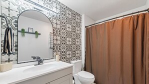 A bathroom with a white sink, a toilet, and a shower curtain. - Perfectly located Home, Spa + Mini golf - Villa 2 (Ridgefield)