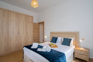A hotel room with a large wardrobe, a bed with a headboard, bedside tables, and a nightstand. - Casa dos Amigos by Galmi (Câmara de Lobos)