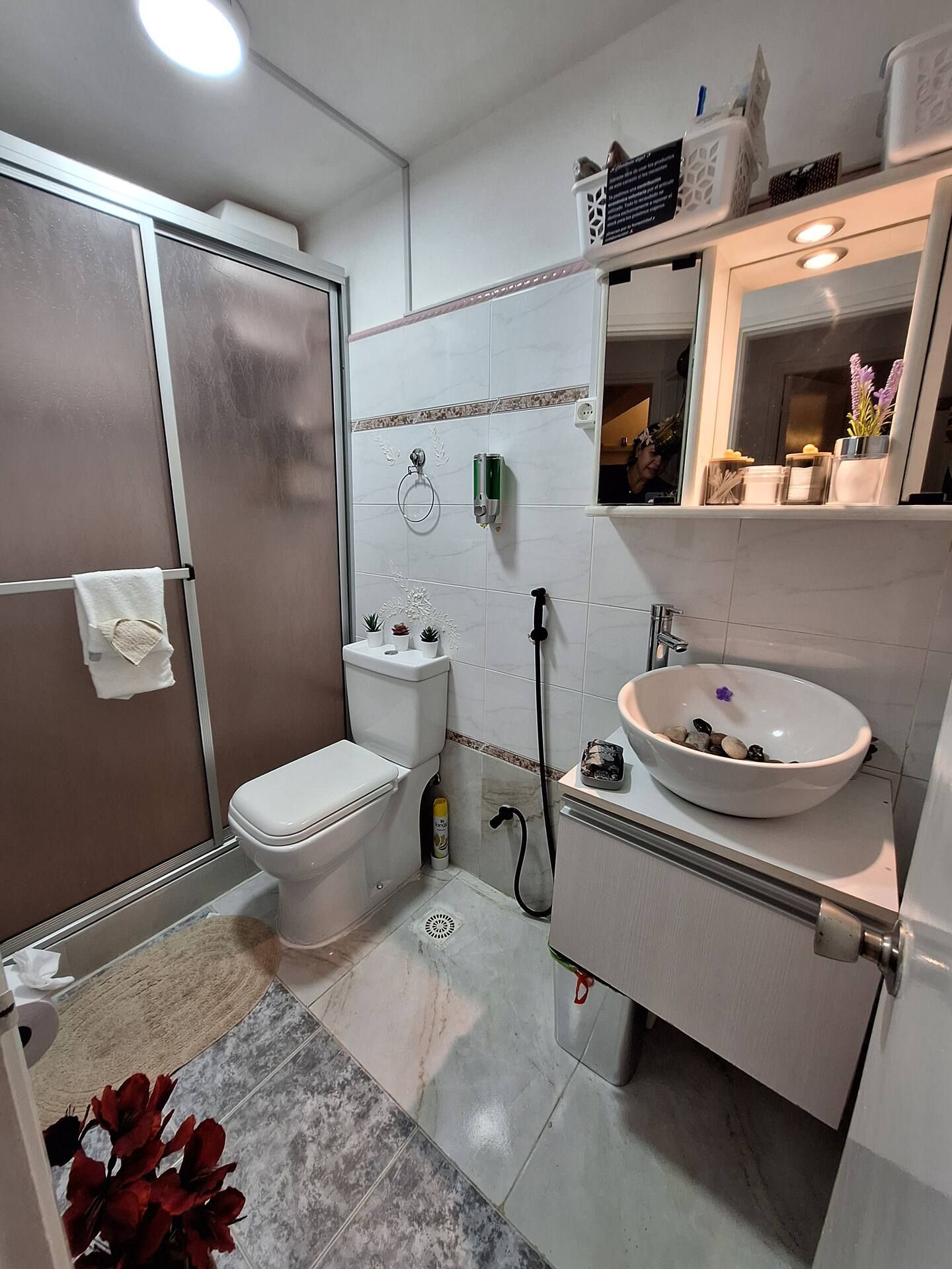 A bathroom with a toilet, bidet, sink, and a mirror above the sink.