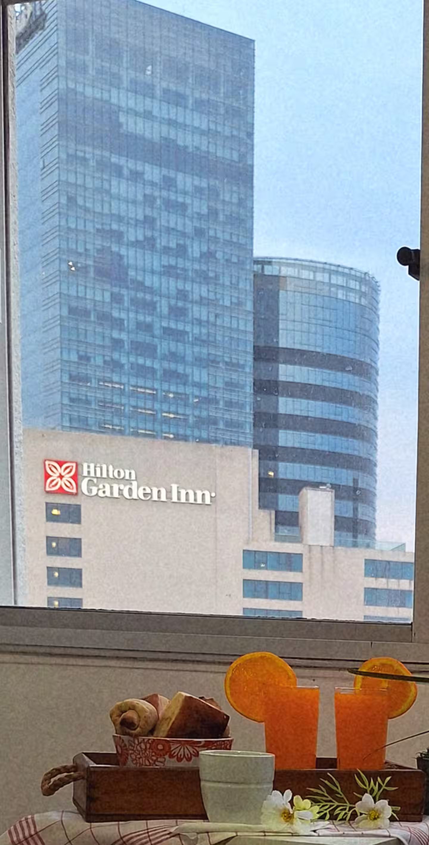 A view of Hilton Garden Inn's exterior with a dining table set with orange slices and a floral arrangement.