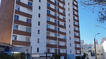 A multi-story residential building with a brick facade and white upper sections.