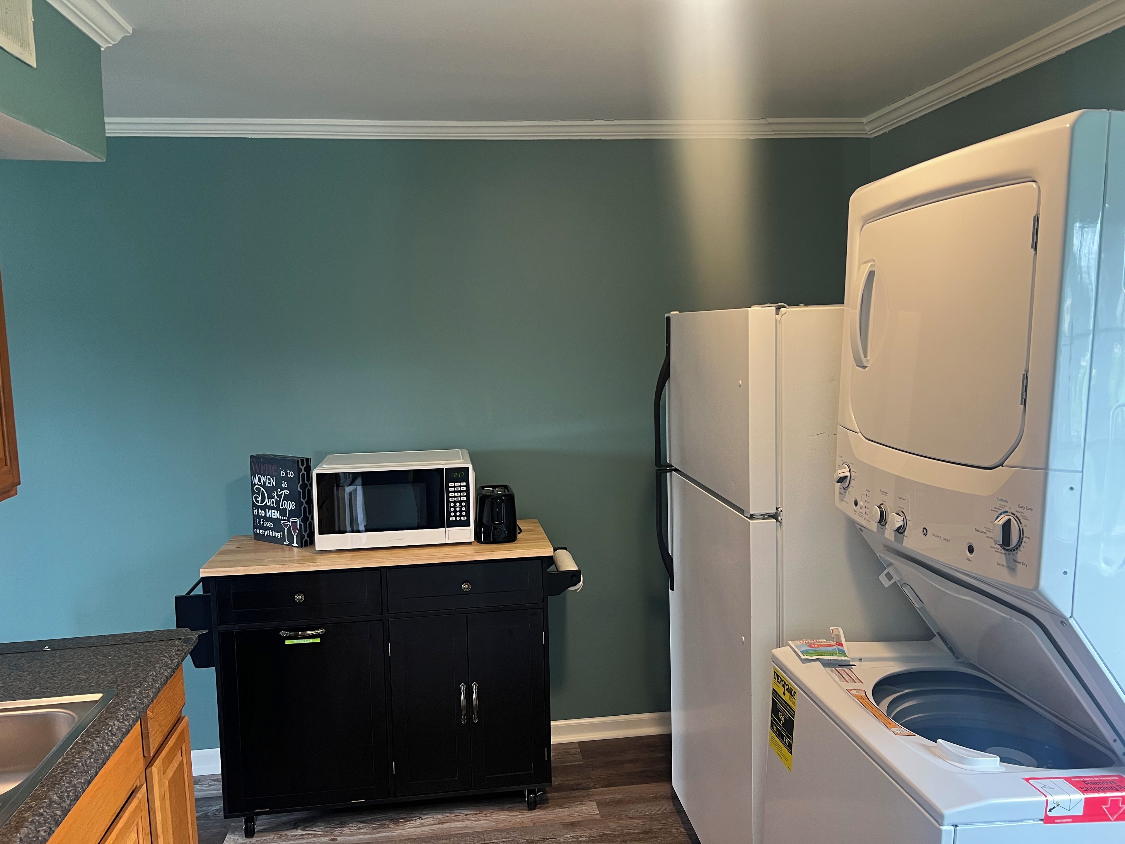 Cocina compacta con microondas, refrigerador y lavadora.