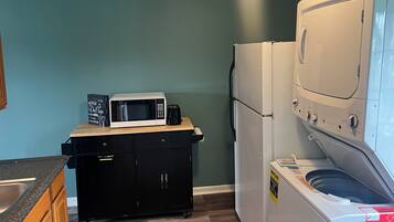 Cocina compacta con microondas, refrigerador y lavadora.