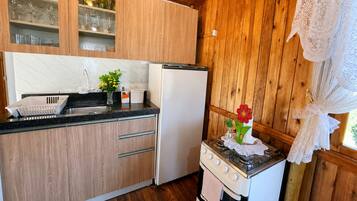 Una cocina con armarios de madera, un refrigerador, una estufa y un lavamanos.