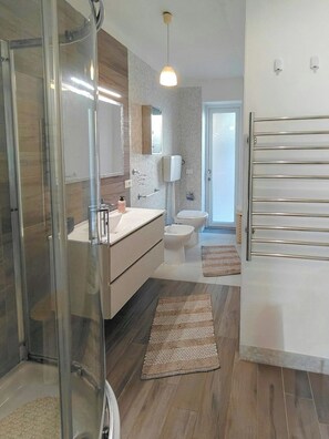 A modern bathroom with a glass shower enclosure, a white sink, a toilet, and a mirror above the sink. - Design villa with pool and jacuzzi near Selinunte (Triscina)
