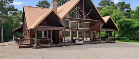 A large wooden lodge with a prominent gable roof, multiple windows, and a covered porch area.