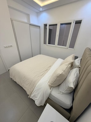 A bedroom with a bed, a window, and a door. - Palm House Tanger Apartment 02 (Tanger)
