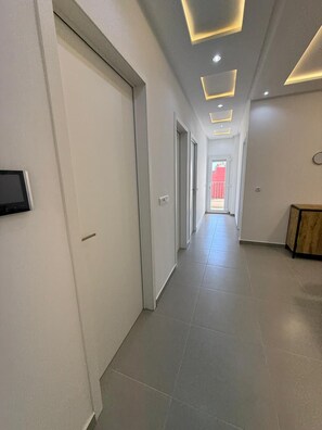 A corridor with white walls, a tiled floor, and recessed lighting. - Palm House Tanger Apartment 02 (Tanger)