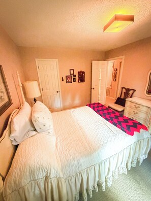 A bedroom with a bed, a dresser, a lamp, and a ceiling light fixture. - Home in Golf Course Community- minutes from everything (Oxford)