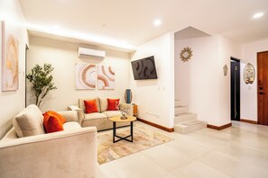 Ein modernes Wohnzimmer mit einer Couch, einem Couchtisch und Kunstwerken an den Wänden.
