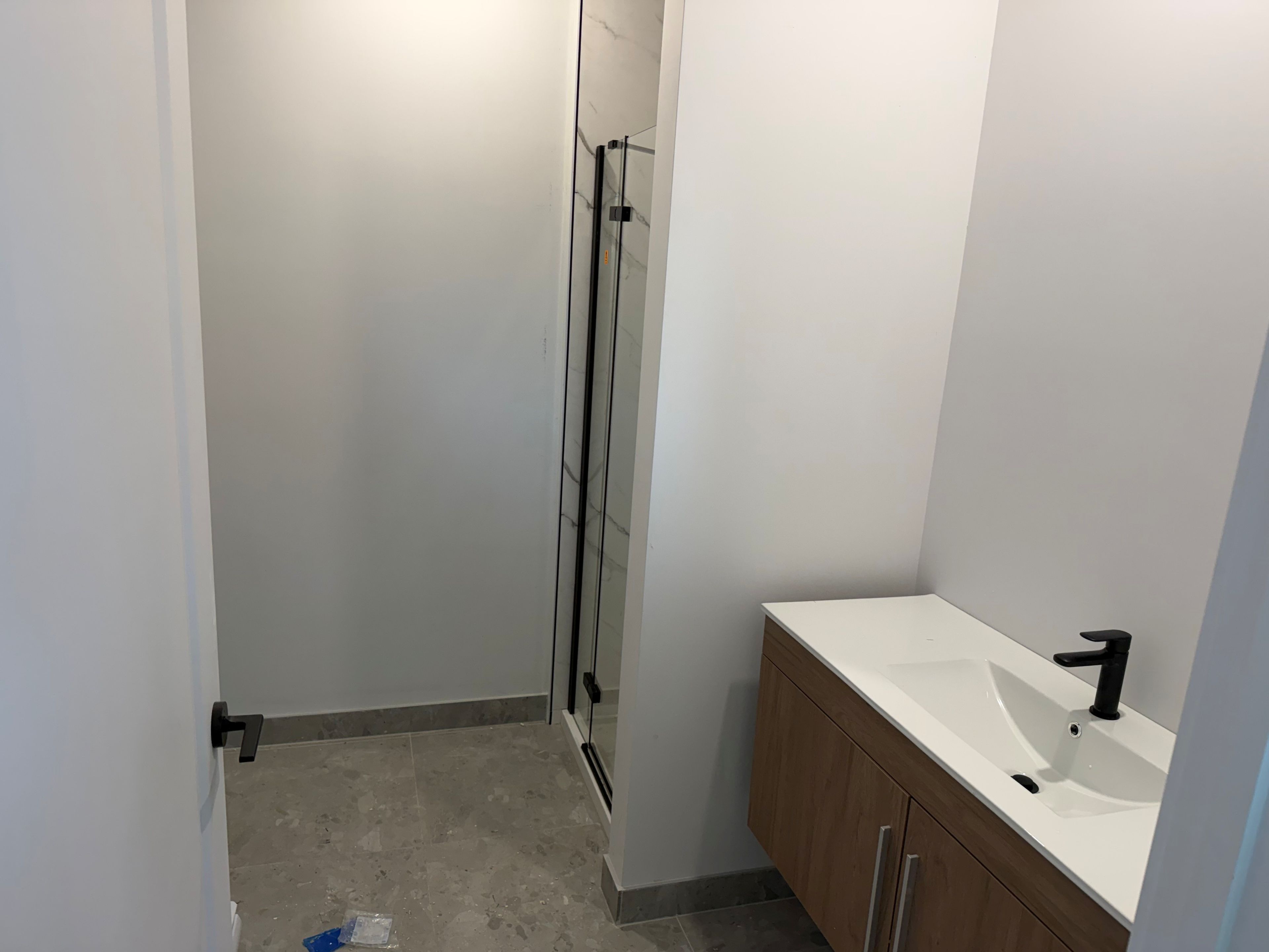 Ein Badezimmer mit Dusche, Waschbecken und Holzschränken.