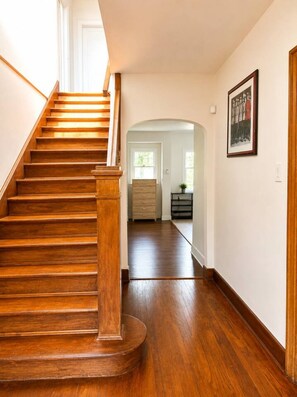 A wooden staircase leading to a landing with a view of a hallway and a door. - Grand King Suite | 5-10 Min to Airport & Downtown (Vancouver)